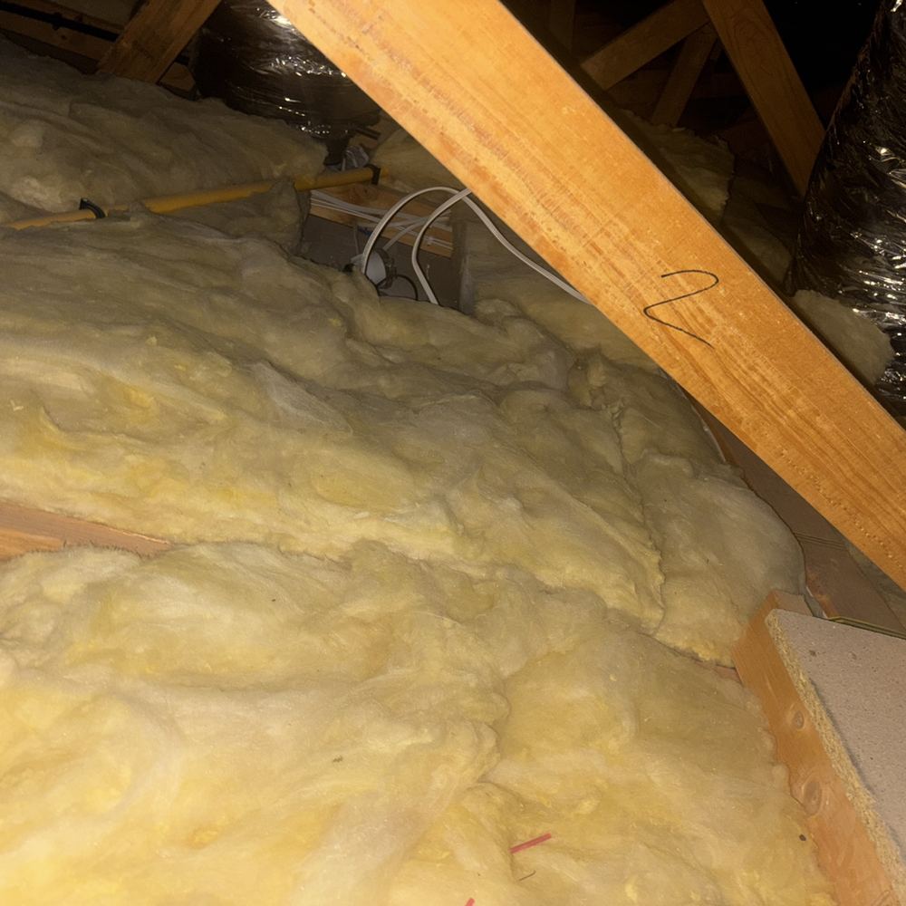 Downlight buried in insulation without the clearance that limits fire risk, found during a pre-purchase inspection in Kalkallo